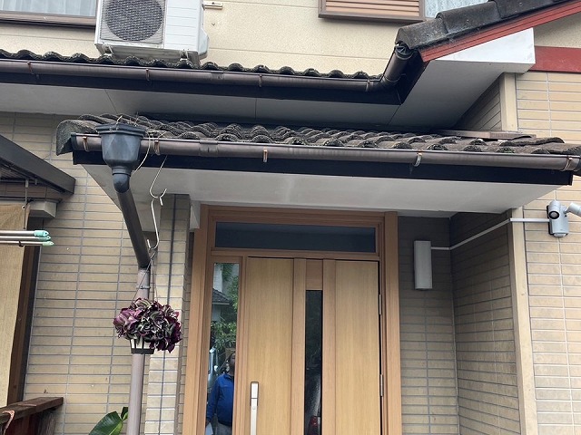 住宅玄関上部の軒樋と竪樋、瓦屋根の全景