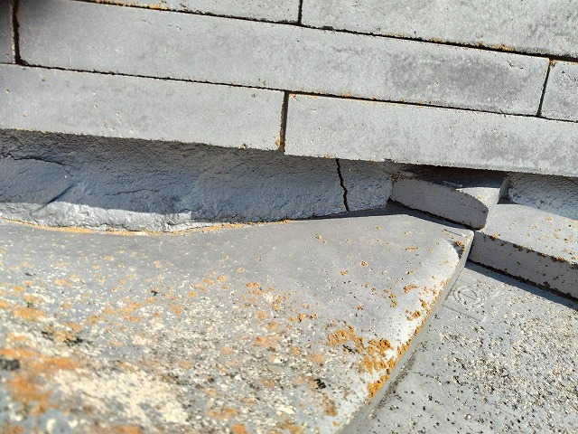 漆喰詰め直し工事を行う住宅棟の漆喰にひび割れが生じている状況