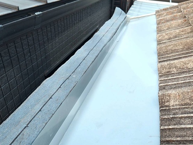 幅を広くした谷板金の設置後、笠木の設置を控えたパラペット際の状態