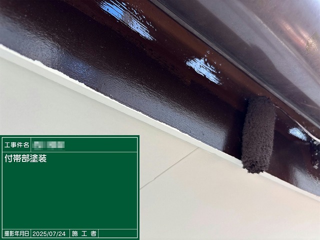 鼻隠しや破風板などの付帯部ににローラーでツヤのある塗料を塗布している様子