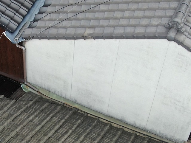 隣家の屋根との取り合い部に設置された谷板金に腐食が見られる様子