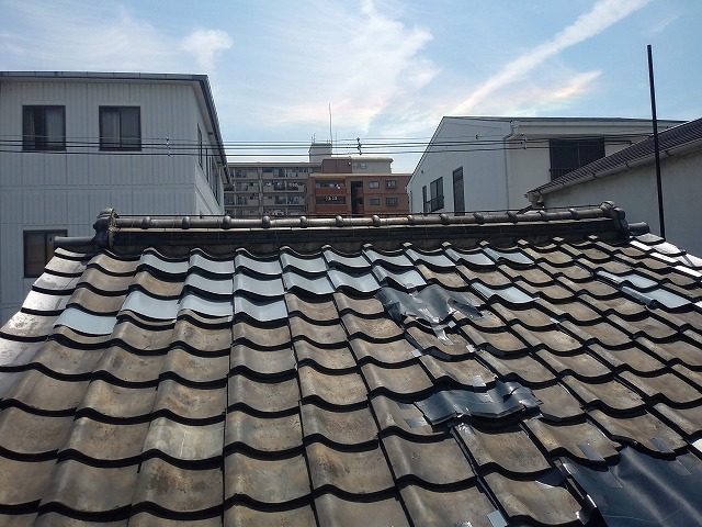 応急処置が施された古い瓦屋根