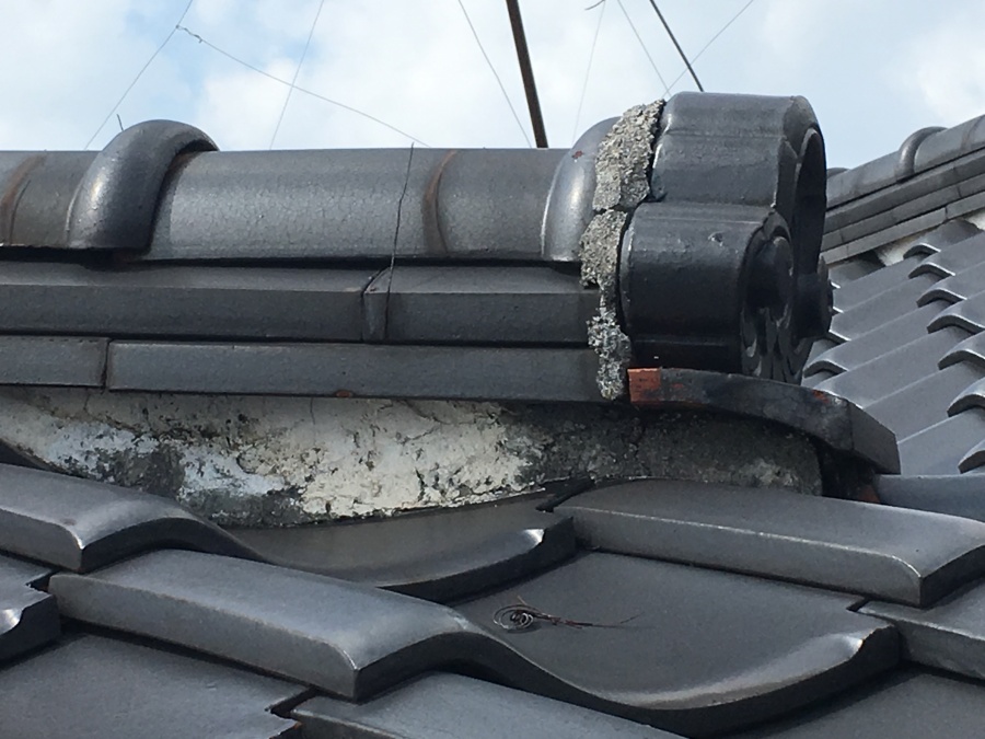 剥がれかけた鬼瓦まわりの漆喰