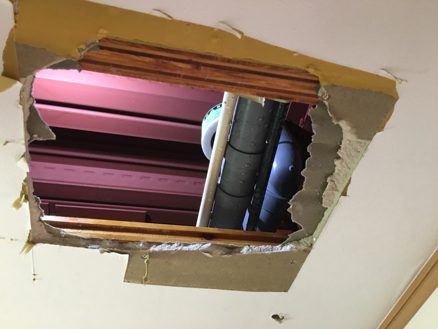 天井から雨水が漏れ落ちているので調査で穴を開けているところ