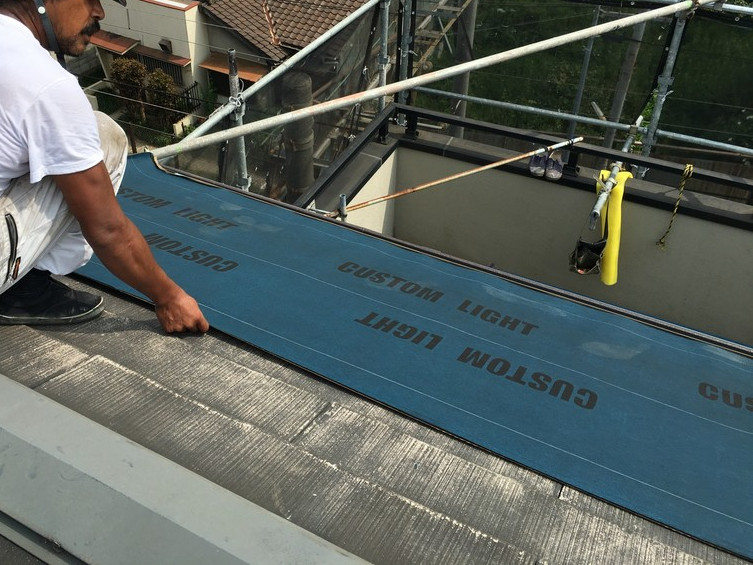 片面粘着ルーフィングを施工中