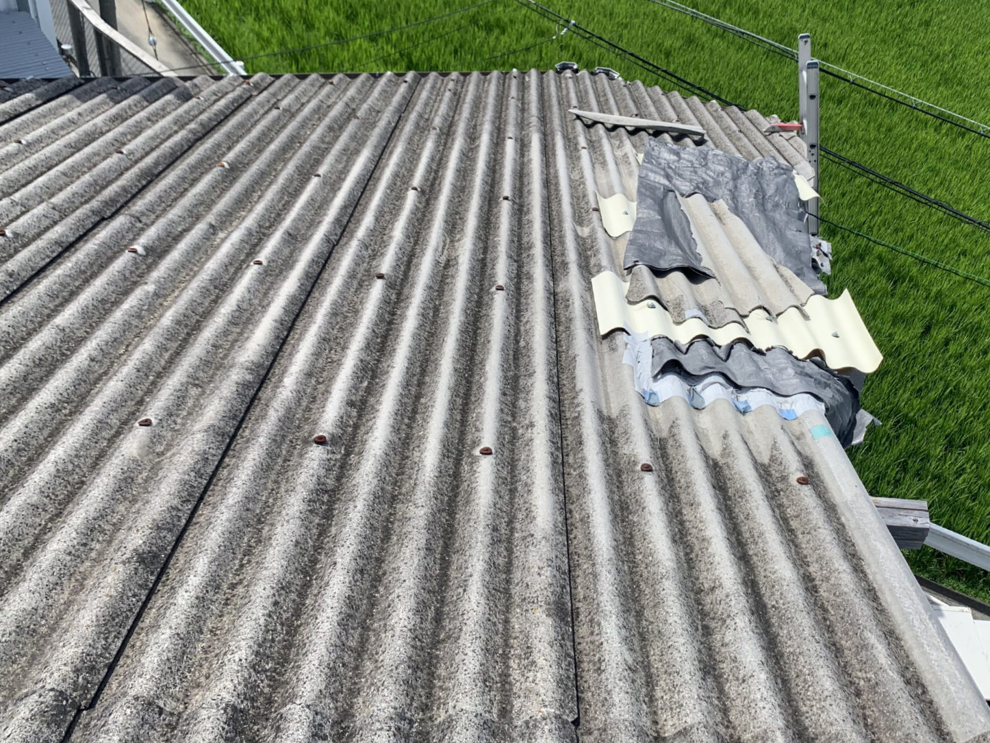 部分的に応急処置がなされた波板スレート屋根