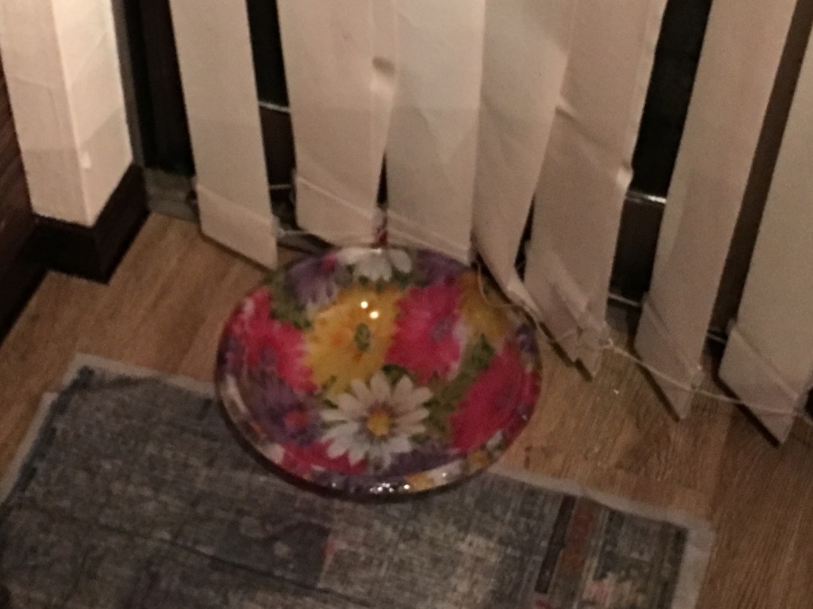 天井からの雨水を容器で受け止めている様子