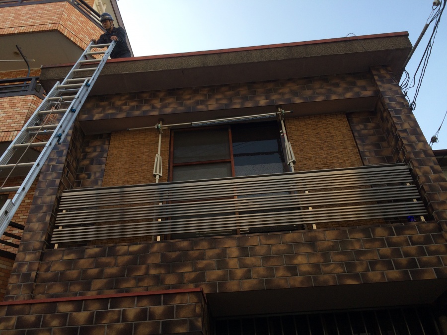 梯子で屋根調査に上がる職人