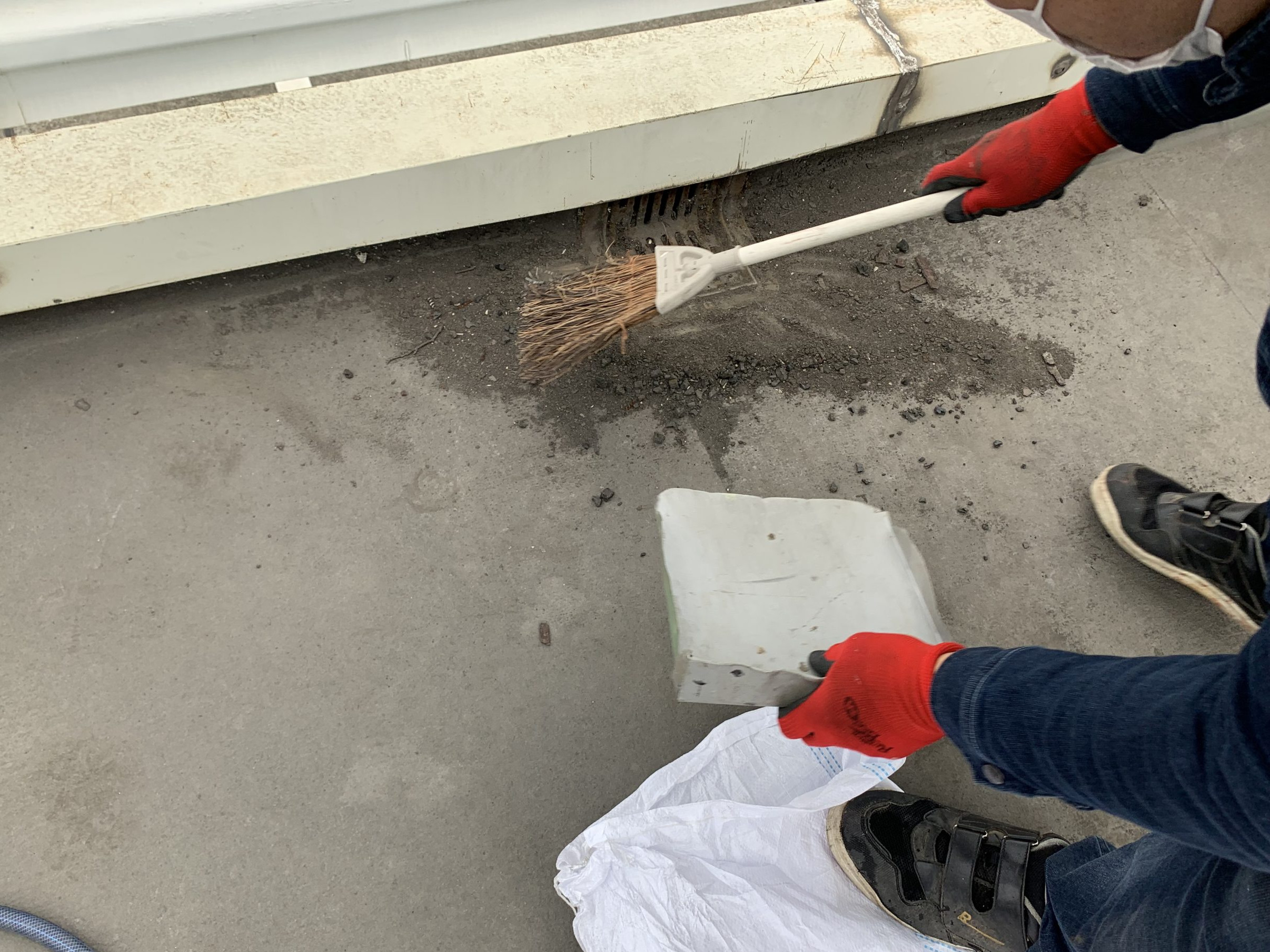 陸屋根のドレンまわりを清掃中