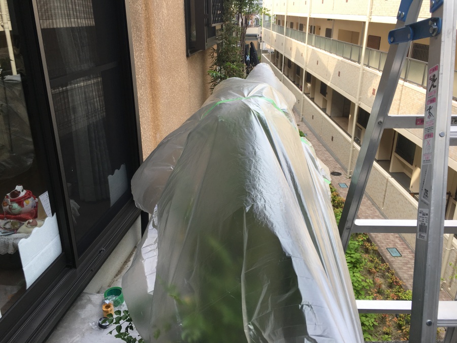 ベランダの養生カバーを掛けられた植物