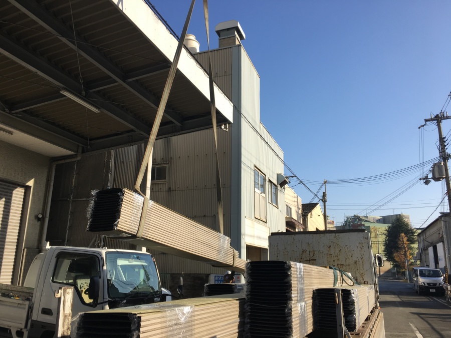 クレーンで持ち上げられる鋼板