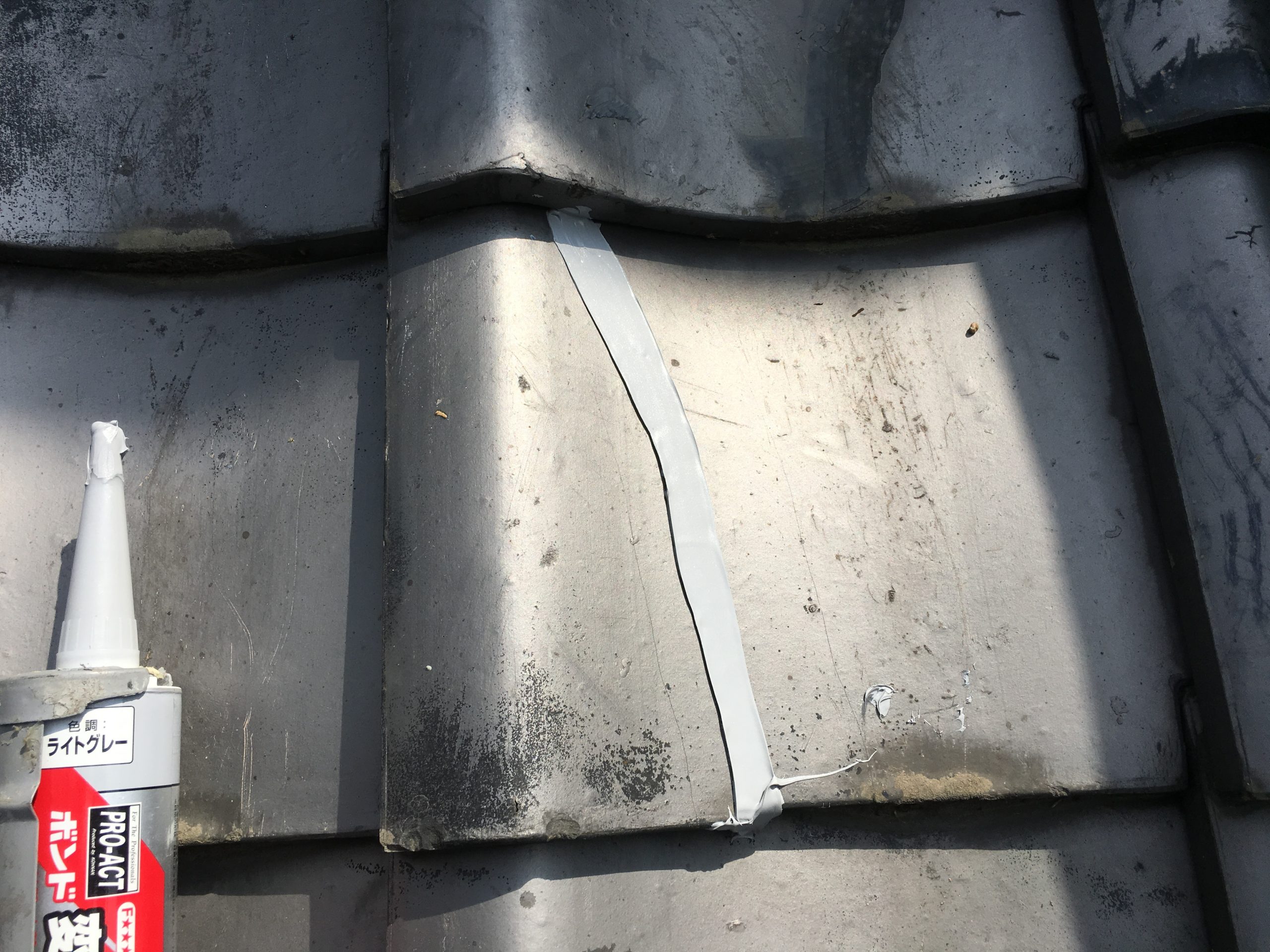 雨漏り原因となっている瓦の割れをコーキングで応急処置