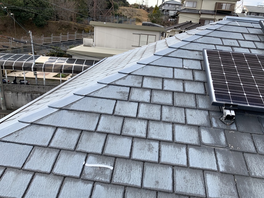 スレート屋根の一部がコーキング補修されている様子