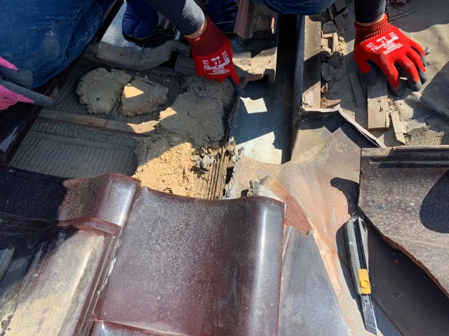 瓦をめくって雨漏り箇所を確認中