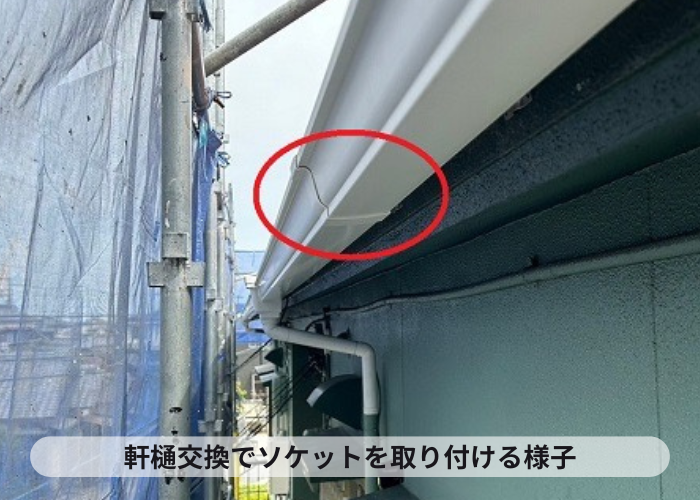 2階建てアパートの軒樋交換でソケットを取り付けている様子