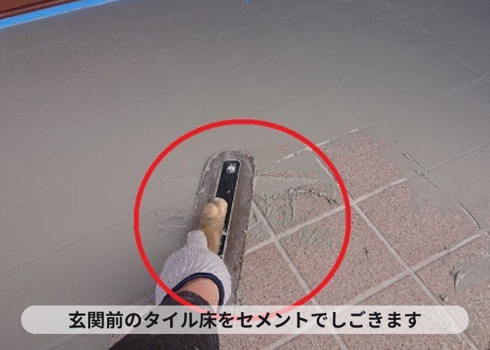 吹田市玄関前のタイル部をセメントでしごいている様子