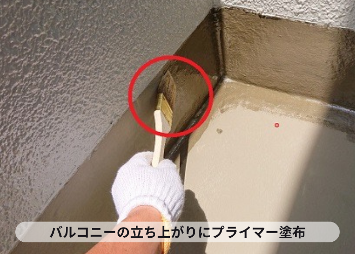 バルコニーへの防水工事で立ち上がりにプライマーを塗っている様子