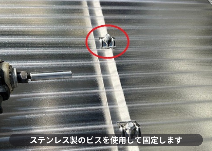 ストックヤードの屋根交換でステンレス製のビスでポリカ波板を固定している様子