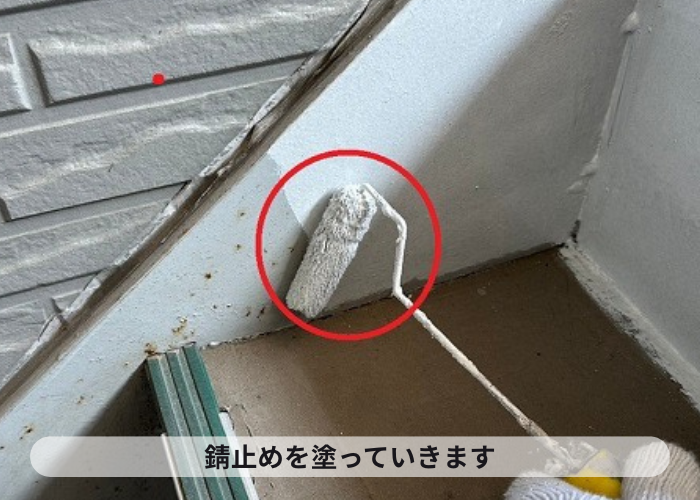 鉄骨階段に錆止めを塗っている様子