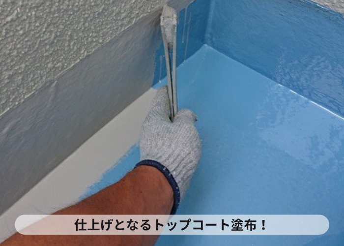ベランダ防水工事でトップコートを塗っている様子