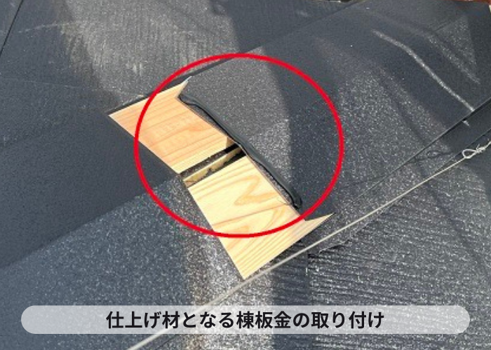 屋根カバー工事で仕上げ材となる棟板金を取り付けている様子