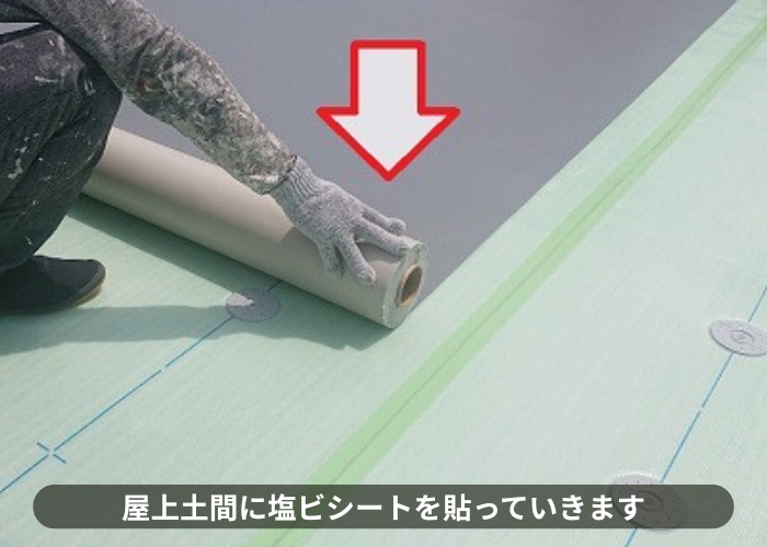 吹田市 屋上防水工事で土間に塩ビシートを貼っている様子