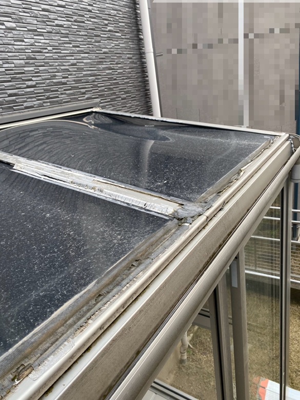 サンルーム屋根のパネルが落雪により歪んでいます