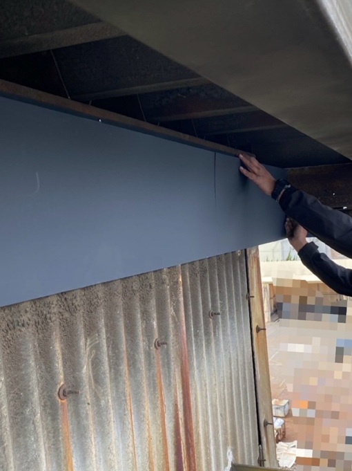 すき間（黄色い矢印）を塞ぐためのガルバリウム鋼板をビスで固定していきます。