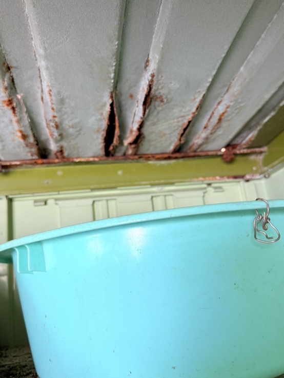 経年劣化により、物置の金属屋根にサビが出て穴があき、雨漏りしています。 お客様は応急処置としてバケツを設置し、屋根から落ちてくる雨水を受け止めておられました。 特に屋根の隅部分のサビがひどく、穴が数か所あいていました。