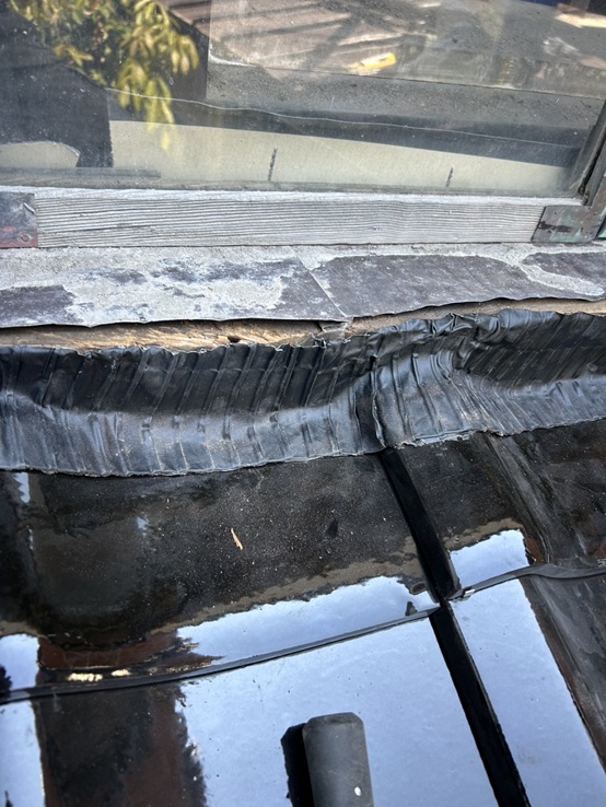 下屋根の瓦屋根と壁面のすき間から雨が入り込まないように面戸ロールを貼ります