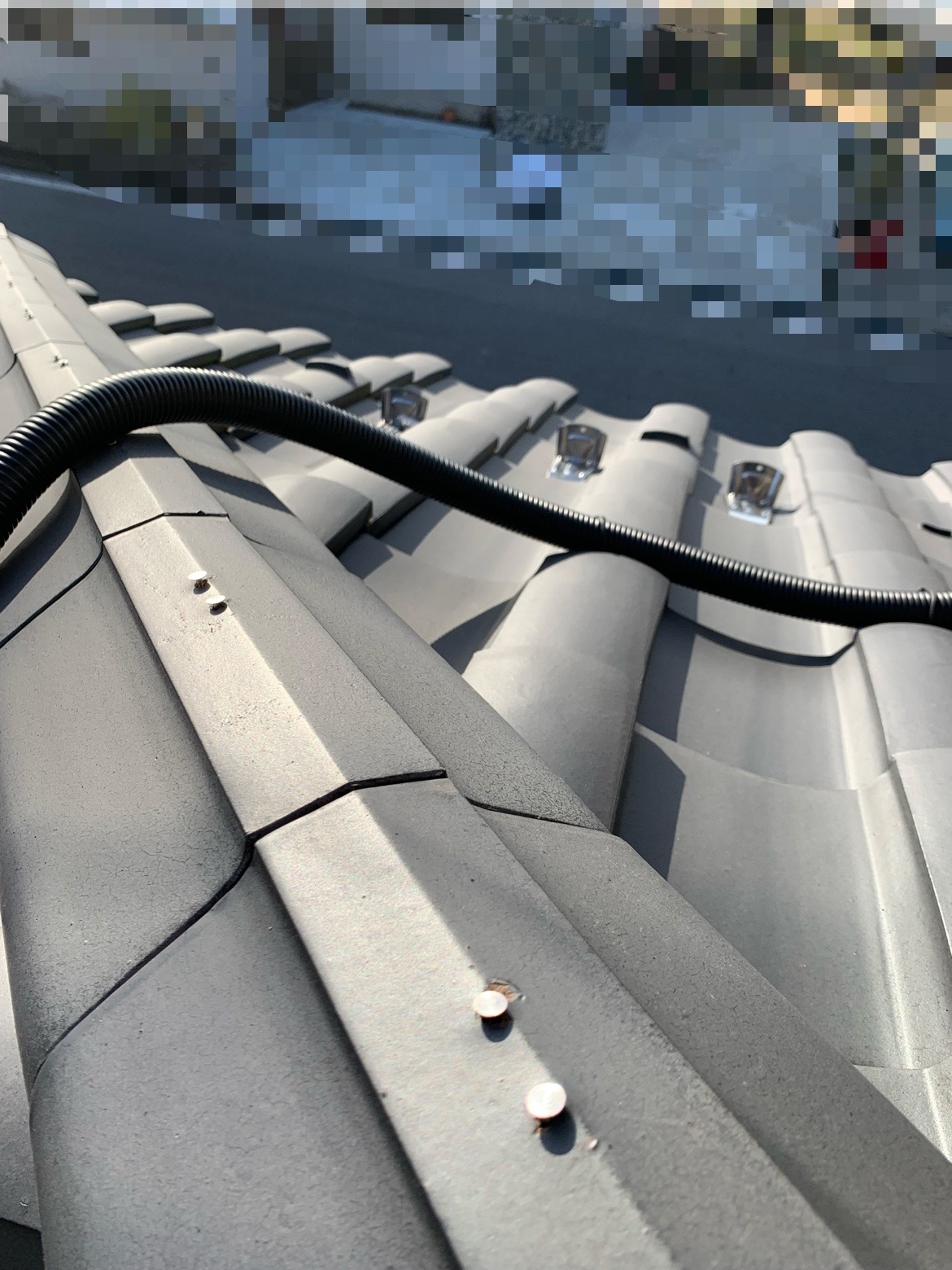 棟瓦を固定している釘が浮いています