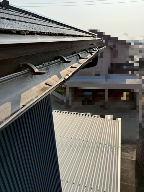 雨どいの金具が折れて傾いています