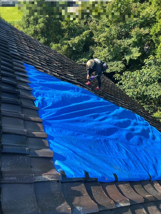 雨漏りした瓦屋根にブルーシートで養生